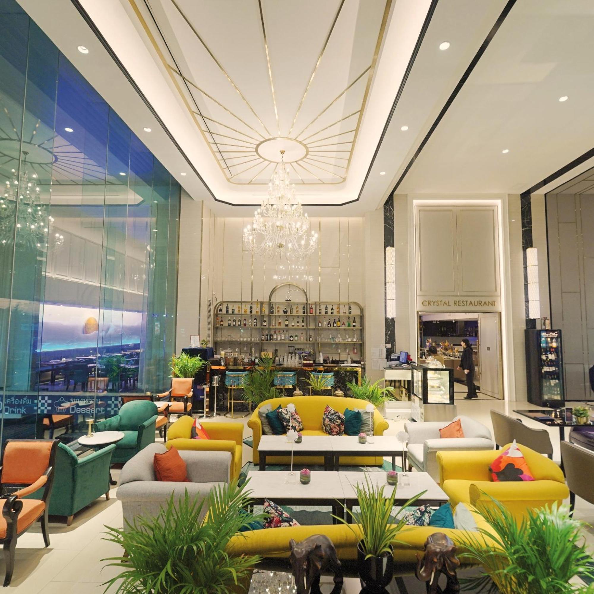 סאמוט פראקאן Siam Mandarina Hotel - Free Bkk Airport Shuttle מראה חיצוני תמונה The photo shows a stylish and modern lounge area, featuring a contemporary design. The space includes bright, colorful furniture, such as yellow, orange, and green sofas and chairs, arranged around white tables. In the center, there is a decorative b